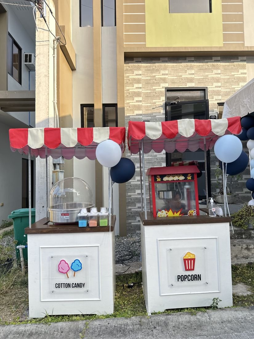 Cotton candy and popcorn carts with blue and white balloons