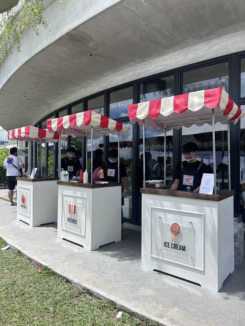 Crew at the fries, hotdog and ice cream carts on a sunny day