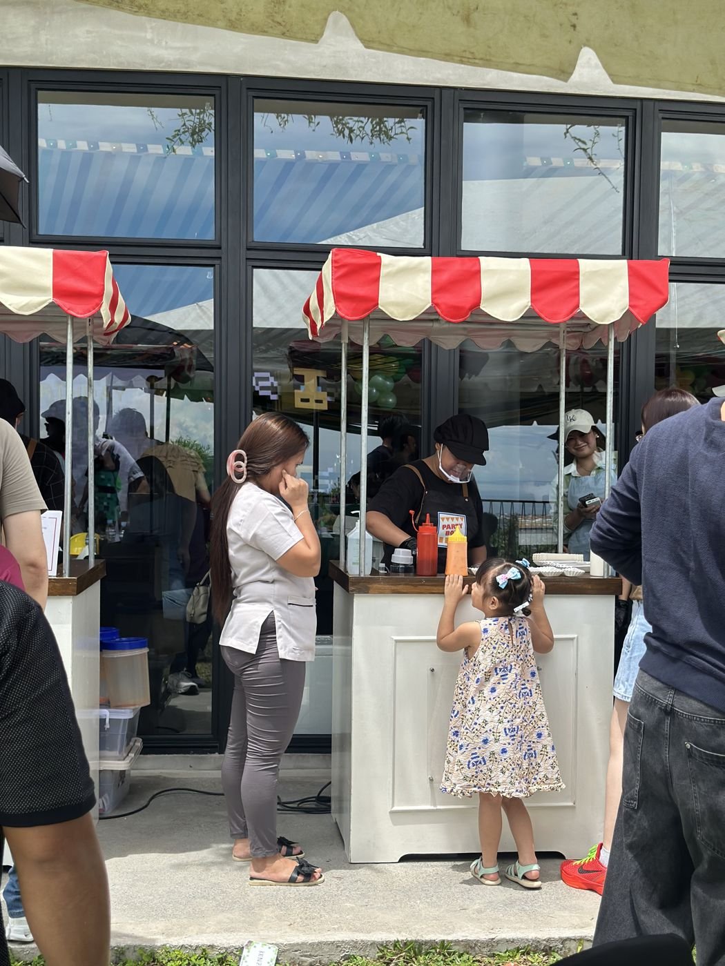 A little girl peeking over a PartyBox cart counter